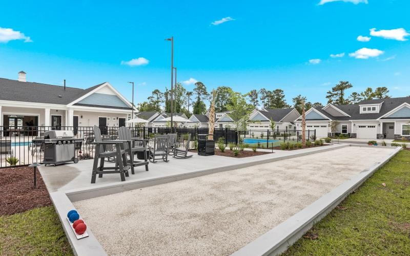 Outdoor lounge at River Rock at Shingletree 55 and over community in North Carolina, featuring bocce ball and tennis courts.